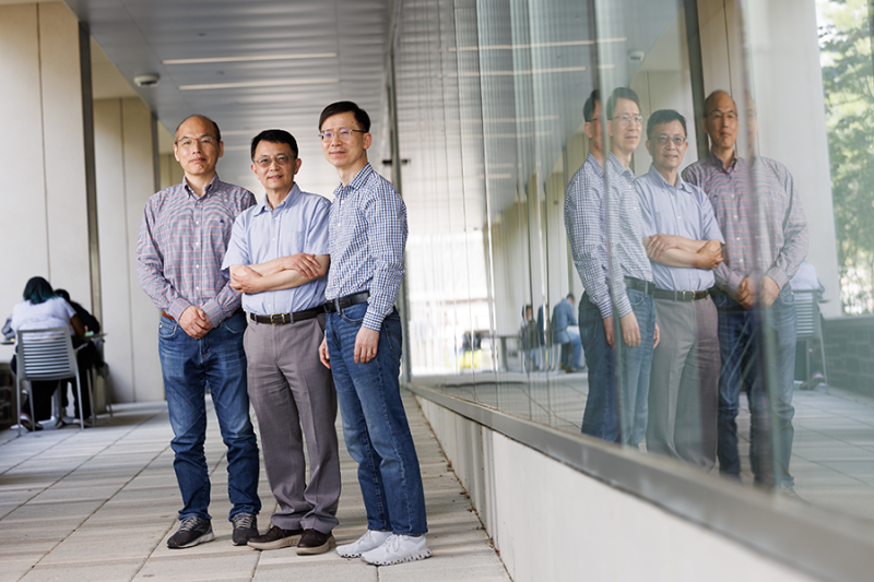Three researchers standing outside of a building