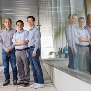 Three researchers standing outside of a building